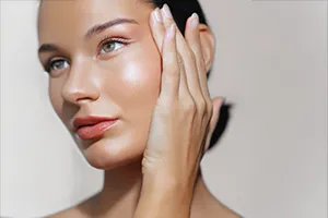 woman with beautiful skin gently touching face